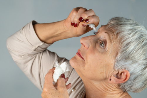 older woman putting in eyedrops